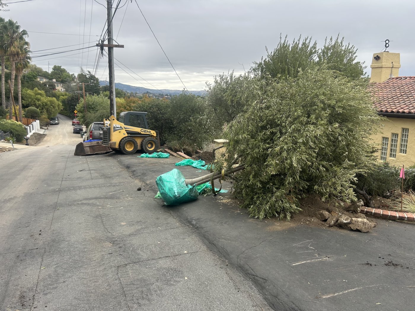 Skid-steer loader and debris removal on a tight-access residential hillside street